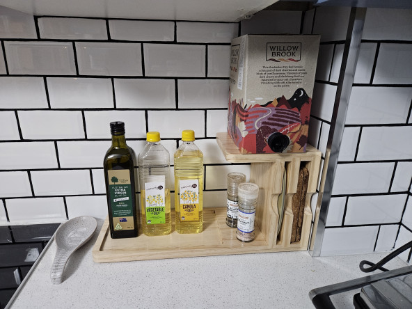 A wooden caddy for cooking oils, red wine, cork heat mats and kitchen scales